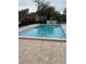 Community swimming pool surrounded by brick pavers and mature trees at 8001 Jasmine Dr # 8001, Temple Terrace, FL 33637