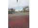 Community tennis court with green and red painted surface, surrounded by mature trees at 8001 Jasmine Dr # 8001, Temple Terrace, FL 33637