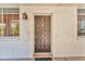 Charming covered front door with decorative sconce lighting and a textured stucco wall at 1001 Pearce Dr # 106, Clearwater, FL 33764