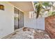 Cozy condo patio with sliding glass doors, painted stucco and brick walls, plus tropical foliage at 1001 Pearce Dr # 106, Clearwater, FL 33764