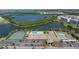 Aerial view of a community building with a pool, tennis courts, parking, and lake view at 10038 62Nd N Ter # 1, St Petersburg, FL 33708