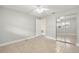 Neutral-toned bedroom with tile floors, ceiling fan, mirrored closet, and access to additional rooms at 10038 62Nd N Ter # 1, St Petersburg, FL 33708