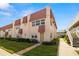 Exterior view of condo building with unique roof design, lush lawns, and walkways at 10038 62Nd N Ter # 1, St Petersburg, FL 33708