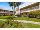 Condo buildings with lawns, sidewalks, mature trees, and stairs to the second story units at 10038 62Nd N Ter # 1, St Petersburg, FL 33708
