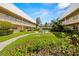 Lush courtyard with manicured lawn, landscaping, benches, and walkways between condo buildings at 10038 62Nd N Ter # 1, St Petersburg, FL 33708