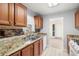 Well-lit kitchen boasts granite countertops, stainless steel sink, dishwasher, and stylish tiled backsplash at 10038 62Nd N Ter # 1, St Petersburg, FL 33708