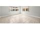 Bright living room featuring tile floors, baseboards, two windows, and fresh paint at 10038 62Nd N Ter # 1, St Petersburg, FL 33708
