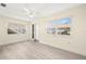 Light-filled living room boasts wood-look floors, white walls, and large windows with exterior views at 10038 62Nd N Ter # 1, St Petersburg, FL 33708