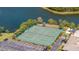 Aerial view of community tennis courts near the water, surrounded by lush landscaping and parking at 10038 62Nd N Ter # 1, St Petersburg, FL 33708