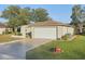 Attached single car garage with a white door and a manicured lawn at 10722 Footprint Ln, Port Richey, FL 34668