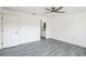 Open bedroom with wood-look flooring, a modern ceiling fan, and an en-suite bathroom view at 114 25Th E St, Palmetto, FL 34221