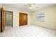 Bright bedroom with tile floors, ceiling fan, closet, and window with blinds at 11845 Meadowdale Dr, Tampa, FL 33625