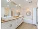 Bright bathroom featuring double sinks, a soaking tub, and wood-look tile flooring at 1200 Gulf Blvd # 902, Clearwater Beach, FL 33767