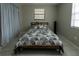 Neutral bedroom with geometric bedding, tile floors, and a bright window at 1206 N Bracewell Dr, Plant City, FL 33563