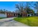 Charming brick home with a well-manicured lawn and a curved driveway, providing ample parking space at 1206 N Bracewell Dr, Plant City, FL 33563