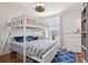 Bedroom featuring a bunk bed with wood floors, natural light, and blue accents at 12225 Lake Blvd, New Port Richey, FL 34655