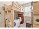Cozy bedroom featuring a wooden bunk bed frame, a dresser, and natural light from the window at 12225 Lake Blvd, New Port Richey, FL 34655