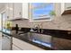 Close up of a kitchen sink with granite countertops, a window view, and mosaic tile backsplash at 12225 Lake Blvd, New Port Richey, FL 34655