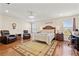 Spacious main bedroom featuring hardwood floors, ceiling fan, lots of sunlight, comfortable seating and stylish decor at 12225 Lake Blvd, New Port Richey, FL 34655