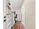 Hallway with home office featuring white shelving, wood floors, a desk, and a chair at 12225 Lake Blvd, New Port Richey, FL 34655
