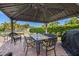 A covered outdoor patio features brick pavers, a dining table, ceiling fans, and a manicured lawn at 12225 Lake Blvd, New Port Richey, FL 34655
