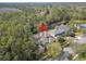 An aerial view displays a beautiful home nestled in a serene setting surrounded by lush greenery and nearby water at 14841 Tudor Chase Dr, Tampa, FL 33626