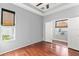 Spacious bedroom featuring hardwood floors, tray ceilings, neutral-colored walls, and a window with woven blinds at 14841 Tudor Chase Dr, Tampa, FL 33626