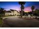 Elegant two-story home featuring a circular driveway with a fountain and manicured landscaping with large palm trees at 14841 Tudor Chase Dr, Tampa, FL 33626