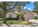 Charming two-story home featuring a well-manicured lawn, beautiful landscaping, and an attached two-car garage at 14841 Tudor Chase Dr, Tampa, FL 33626