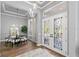Bright foyer with decorative glass double doors, hardwood floors, and a view into the adjacent dining space at 14841 Tudor Chase Dr, Tampa, FL 33626