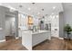Modern kitchen features white cabinetry, stainless steel appliances, hardwood floors, and a large center island at 14841 Tudor Chase Dr, Tampa, FL 33626