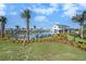 Community pool area with lounge chairs, umbrellas, palm trees, and a clubhouse at 20778 Balsam Hill Rd, Land O Lakes, FL 34638