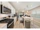 Modern kitchen with stainless steel appliances, white cabinets and quartz countertops at 20778 Balsam Hill Rd, Land O Lakes, FL 34638