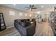 Open-concept living room boasts natural light, wood floors, modern ceiling fan, and seamless flow into the dining area at 20778 Balsam Hill Rd, Land O Lakes, FL 34638