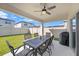 Covered patio with outdoor dining set, ceiling fan, and view of the well-maintained backyard at 20778 Balsam Hill Rd, Land O Lakes, FL 34638