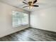 Bright bedroom with window and plank-style floors and wood-panel accent wall at 2253 Norwegian Dr # 67, Clearwater, FL 33763