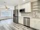 Modern kitchen features stainless steel appliances, white cabinetry, and stylish wood-look flooring at 2253 Norwegian Dr # 67, Clearwater, FL 33763