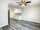 Living room with ceiling fan, wood floors, and white cabinets on the far wall at 2253 Norwegian Dr # 67, Clearwater, FL 33763