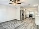 Open-concept living room with wood floors, a ceiling fan, and an adjacent, updated kitchen at 2253 Norwegian Dr # 67, Clearwater, FL 33763