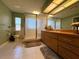 Bathroom featuring a frosted glass shower, neutral tile floors, and wood vanity at 22941 Leafwood Ct, Land O Lakes, FL 34639