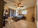Bedroom features wood-look floors, a ceiling fan, and window with natural light at 22941 Leafwood Ct, Land O Lakes, FL 34639