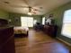 The main bedroom features wood-look floors, a ceiling fan, and natural light from the windows at 22941 Leafwood Ct, Land O Lakes, FL 34639