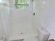 Bright white tiled bathroom with a walk-in shower and a window at 3094 Vernon Ter, Largo, FL 33770