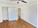 Bright bedroom features hardwood floors, a ceiling fan, and a closet for ample storage at 3094 Vernon Ter, Largo, FL 33770