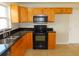 Kitchen featuring black appliances, wooden cabinets, and granite countertops at 3094 Vernon Ter, Largo, FL 33770