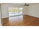 Hardwood floors, ceiling fan, and sliding glass doors to screened patio at 3094 Vernon Ter, Largo, FL 33770