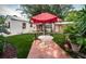 Landscaped backyard with red umbrella, table, and artificial turf at 315 Princess St, Clearwater, FL 33755