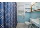 Classic bathroom with blue tile, patterned floor, window, and sink at 315 Princess St, Clearwater, FL 33755