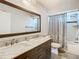 Bathroom featuring a double vanity, a large mirror, and a shower with a curtain at 3212 Player Dr, New Port Richey, FL 34655