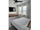Bright bedroom featuring a comfortable bed, modern floating console, and ample natural light from large windows at 35542 Buttonweed, Zephyrhills, FL 33541